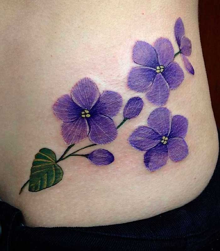 tatuajes de violetas en la cadera